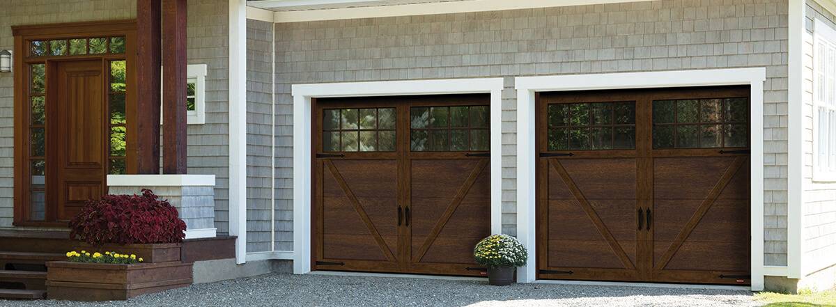 Carriage house garage doors style in Chocolate Walnut Princeton model with Panoramic windows on top on grey rustic house
