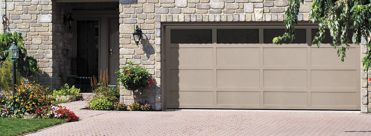 Contemporary garage door style in Clay Cambridge model with clear Panoramic window on top on a stone-facing house